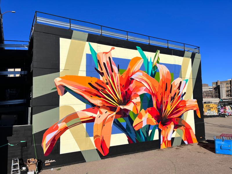 Full alley view of the Prairie Petals mural spanning the brick wall